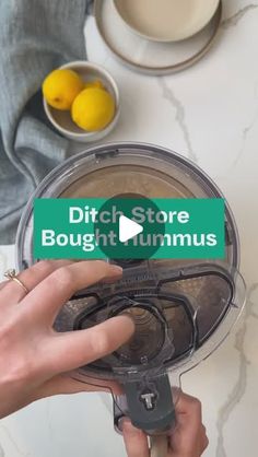 a person holding a green sticker that says ditch store bought hummus in front of a blender