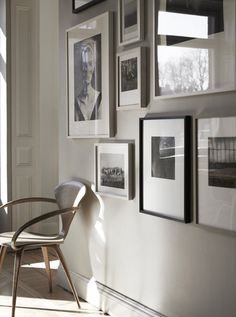 a chair sitting next to a wall with pictures on it