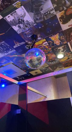 a disco ball hanging from the ceiling in a room with many pictures on the wall