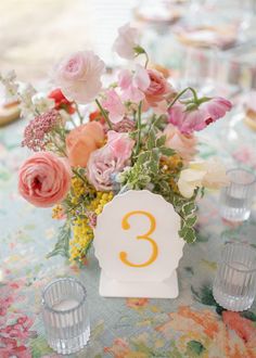 the table is set with flowers and candles for an elegant wedding reception in pastel colors