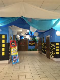 an empty hallway with blue walls and white tile flooring is decorated in legoland