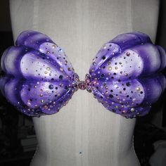 a mannequin with purple and gold sequins on it's back