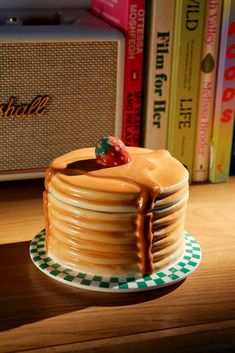 a stack of pancakes sitting on top of a wooden table next to a book shelf