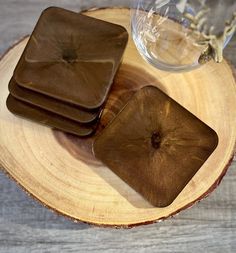 three brown coasters sitting on top of a wooden table