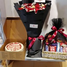 a bouquet of flowers, cake and candy are on display in a room with other items