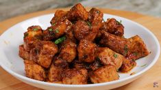 a white bowl filled with tofu sitting on top of a wooden table