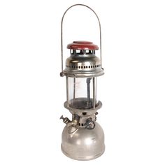 an old fashioned metal lantern with a red light on it's top and handle