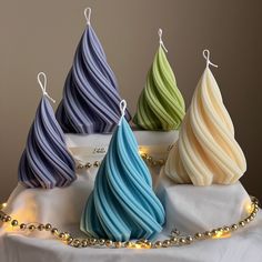 four different colored candles sitting on top of a table