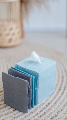 three folded napkins sitting on top of each other in front of a wicker basket