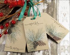 three tags with pine cones and berries on them