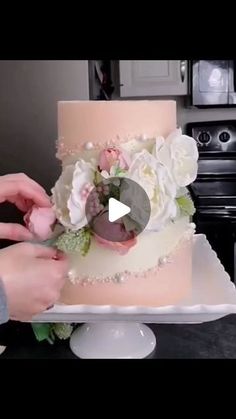 someone is decorating a wedding cake with flowers