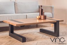 a living room with a couch, table and vases on the floor in front of it