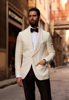 a man in a tuxedo is standing on the street