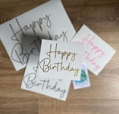 three birthday cards with writing on them sitting on a wooden table next to each other