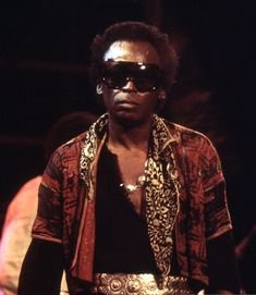 a man with sunglasses on standing in the dark