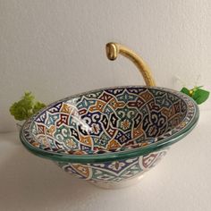 a decorative bowl with handles is sitting on a table