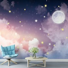 there is a chair and table in front of the wall with clouds and stars on it