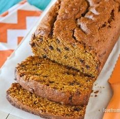 sliced loaf of pumpkin bread sitting on top of a paper towel next to a knife