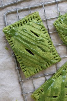 three green pastries sitting on top of a cooling rack