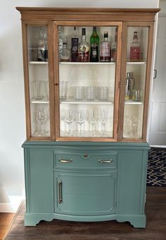 an old china cabinet with wine glasses and liquor bottles