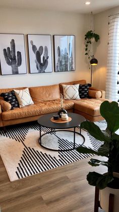 a living room with two couches, a coffee table and three pictures on the wall