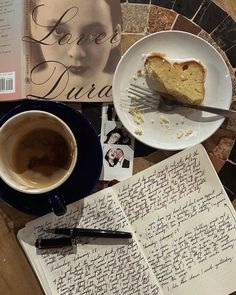 there is a piece of cake next to a cup of coffee and an open book