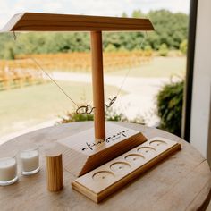 a wooden table topped with two candles and an object on top of it's stand