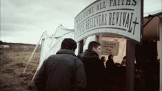 two men standing in front of a sign that says, welcome all fathers and daughters revival