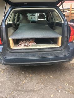 the back end of a blue car with an open hatchback and its cargo compartment