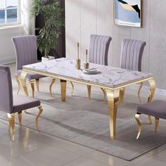 a marble dining table with gold legs and purple chairs