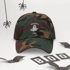 The only hat you need this fall for Halloween/Spooky SZN! Rock this adorable ghost cap with our matching Spoozy SZN sweatshirt: https://quebonito.shop/products/spooky-szn-unisex-sweatshirt • 100% chino cotton twill • Green Camo color is 35% chino cotton twill, 65% polyester • Unstructured, 6-panel, low-profile • 6 embroidered eyelets • 3 ⅛” (7.6 cm) crown • Adjustable strap with antique buckle • Blank product sourced from Vietnam or Bangladesh This product is made especially for you as soon as y Casual Cotton Halloween Hat, Casual Halloween Cap, Halloween Snapback Baseball Cap For Streetwear, Snapback Streetwear Hats For Halloween, Snapback Hats For Halloween Streetwear, Halloween Streetwear Baseball Cap, Casual Halloween Baseball Cap With Curved Brim, Halloween Snapback Hat For Streetwear, Trendy Halloween Cap