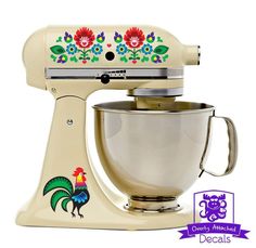 a cream colored mixer with colorful flowers and rooster decals on it's side