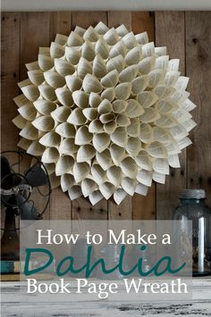 a book page wreath hanging on the wall with text overlay that reads how to make a dahlia book page wreath