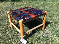 a small wooden stool sitting in the grass