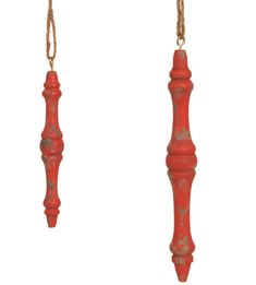 two red candles hanging from chains on a white background