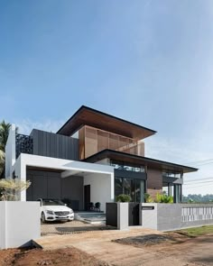 a white car parked in front of a modern house