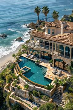 an aerial view of a house with a pool and beach in the foreground, surrounded by palm trees