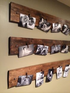 several pictures are hung on wooden pegs with clothes pins attached to the pegs