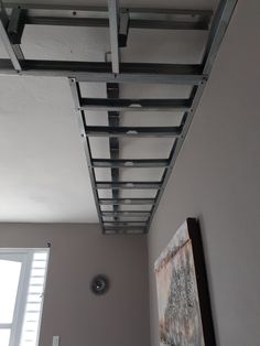 the ceiling in this room is made from metal pipes and has been painted gray with white trim