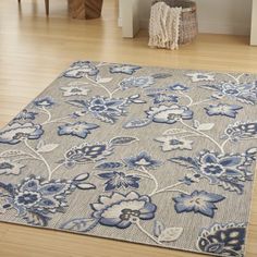 a blue and white rug with flowers on it in the middle of a living room