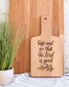 a wooden cutting board with the words taste and see that the lord is good on it