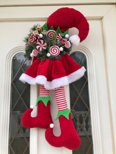 a christmas door hanger decorated with candy canes and santa's stocking