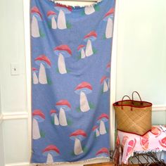 a blue and white wall hanging next to a basket on top of a wooden floor