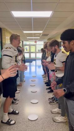 a group of young men standing next to each other in front of a wall with white circles on it