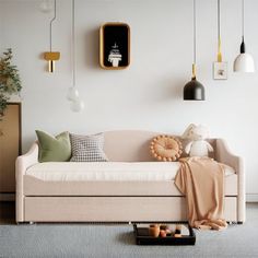 a living room filled with furniture and hanging lights on the wall next to a coffee table