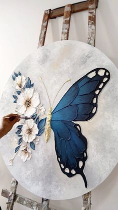 a blue butterfly with white flowers on it's wings sitting on top of a round table