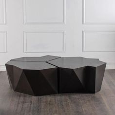 an unusual coffee table made out of wood and black lacquer with geometric shapes