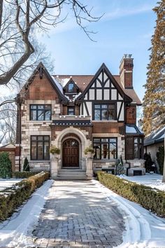 a large brick and stone house in the middle of winter with snow on the ground