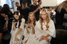 two women sitting next to each other in white dresses