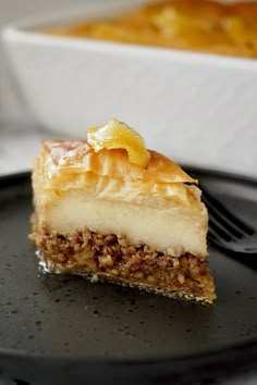 a piece of pie sitting on top of a black plate with a fork in it